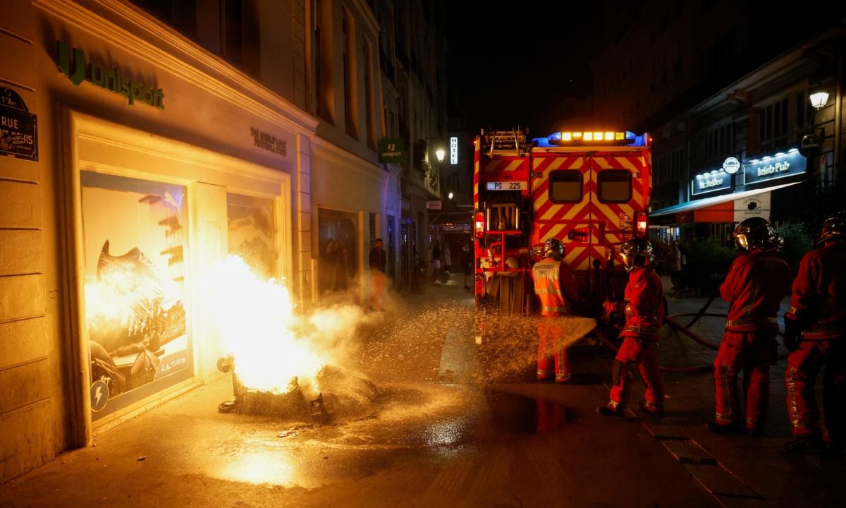 Firefighters work to extinguish a burning container as unrest continues following the death of Nahel, a 17-year-old teenager killed by a French police officer in Nanterre during a traffic stop, in Paris, on July 1, 2023. (Juan Medina/Reuters)