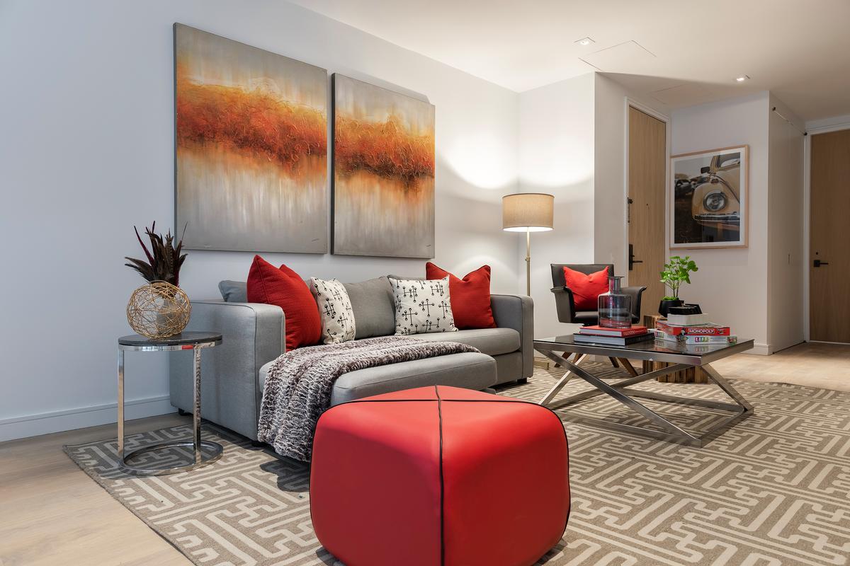 Warm tones are repeated in this family room through the use of artwork, toss pillows and ottoman. (Handout/TNS)