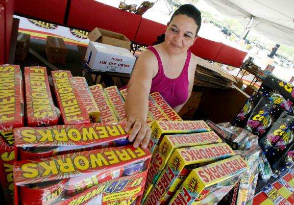 Dominique Tafoya arranges some of the new fireworks stock at a local fireworks concession stand in Phoenix on July 1, 2011. (Ross D. Franklin/AP Photo)