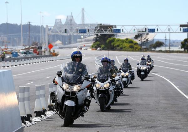 A California Highway Patrol officers ride in formation by the toll plaza before a chain-cutting ceremony to officially open the new eastern span of the San Francisco-Oakland Bay Bridge in Oakland, Calif., on Aug. 30, 2013. (Justin Sullivan/Getty Images)