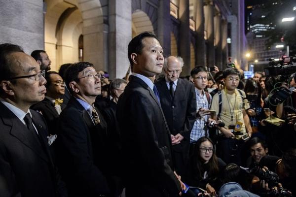 Lawmaker Dennis Kwok (C) stands outside the Court of Final Appeal in Hong Kong on Nov. 8, 2016, after a silent march in protest of a ruling by China that effectively bars two pro-independence legislators from taking office. (Anthony Wallace/AFP via Getty Images)