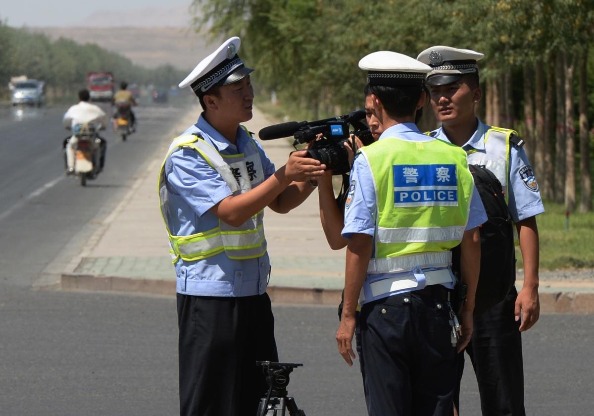 Chinese police detain a journalist at a checkpoint on the road to the riot-affected Uyghur town of Lukqun, Xinjiang Province, China, on June 28, 2013. (Mark Ralston/AFP via Getty Images)