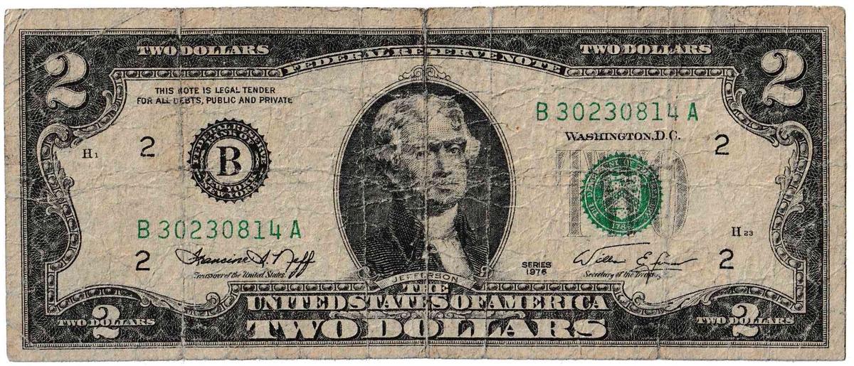 Tờ 2 đô la thuộc dòng sản phẩm 1976 đã bị mòn nhiều, có lẽ là tờ tiền được tìm thấy phổ biến nhất hiện nay. (<a href="https://commons.wikimedia.org/wiki/File:Heavily_Worn_2_Dollar_Bill.jpg">Miền công cộng</a>)