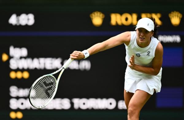 Poland's Iga Swiatek serves the ball to Spain's Sara Sorribes Tormo during their women's singles tennis match on the third day of the 2023 Wimbledon Championships at The All England Tennis Club in Wimbledon, southwest London, on July 5, 2023. (Sebastien Bozon/AFP via Getty Images)