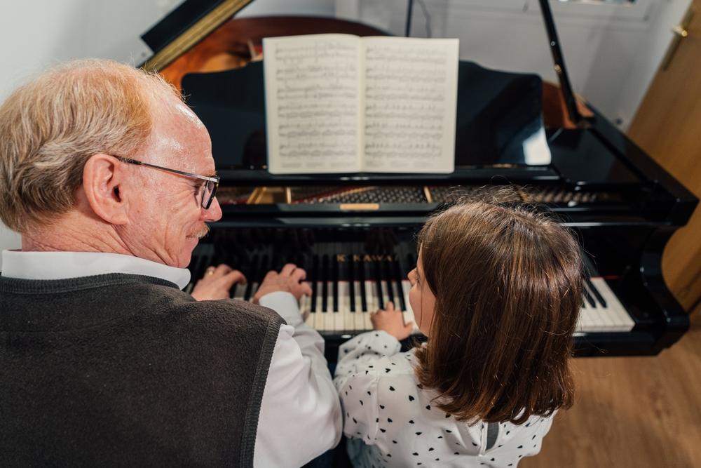 Music lessons can be expensive and out of reach for many families, but lessons taught by a close friend or family member not only teach the skill but reinforces relationships. (Tonet Gandia/Shutterstock)