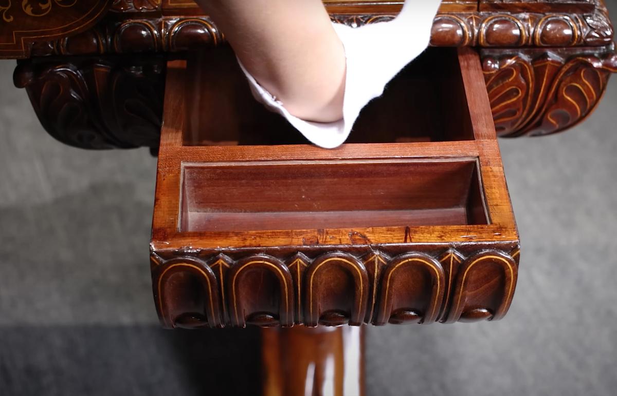 An M. S. Rau auctioneer presses a hidden button located inside the hidden drawers to release more secret compartments. (Courtesy of <a href="https://rauantiques.com/">M.S. Rau, News Orleans</a>)