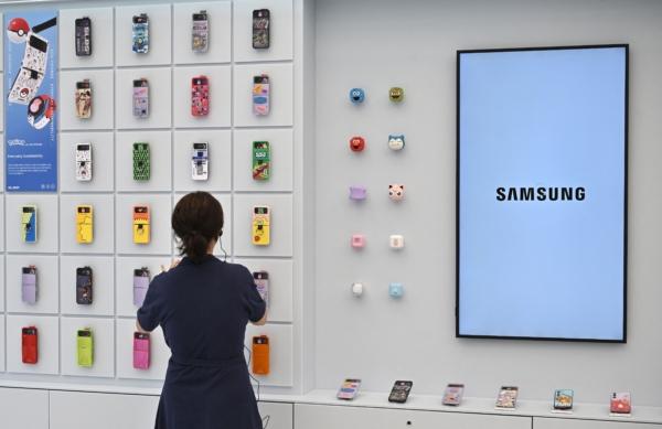A woman looks at accessories of the Samsung Galaxy Z Flip4 displayed on a wall during a media preview event for a new flagship store of Samsung Electronics at the Gangnam district in Seoul on June 28, 2023. (Jung Yeon-je/AFP via Getty Images)
