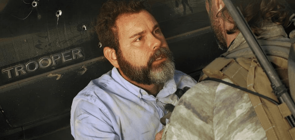 Mortally wounded Rev. Matthew Walters (Jay Moses, L) begs Navy SEAL Richard Mirko (Johnny Strong) to save his daughter, in "Warhorse One." (Well Go USA/Premiere Entertainment)