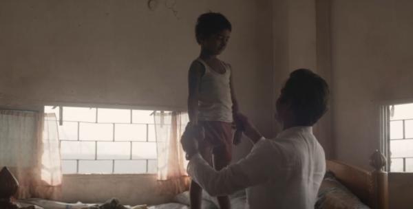 Saroo (Sunny Pawar, L) being inspected by Rama (Nawazuddin Siddiqui), in “Lion.” (Transmission Films)