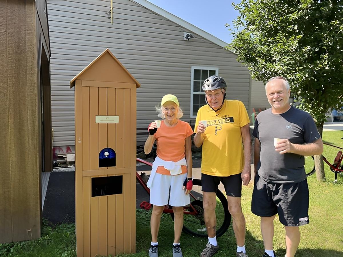 Mr. Eckenrode (C) with bikers who stopped next to his house for water. (Courtesy of Susan Rendulic via <a href="https://nsga.com/">National Senior Games</a>)