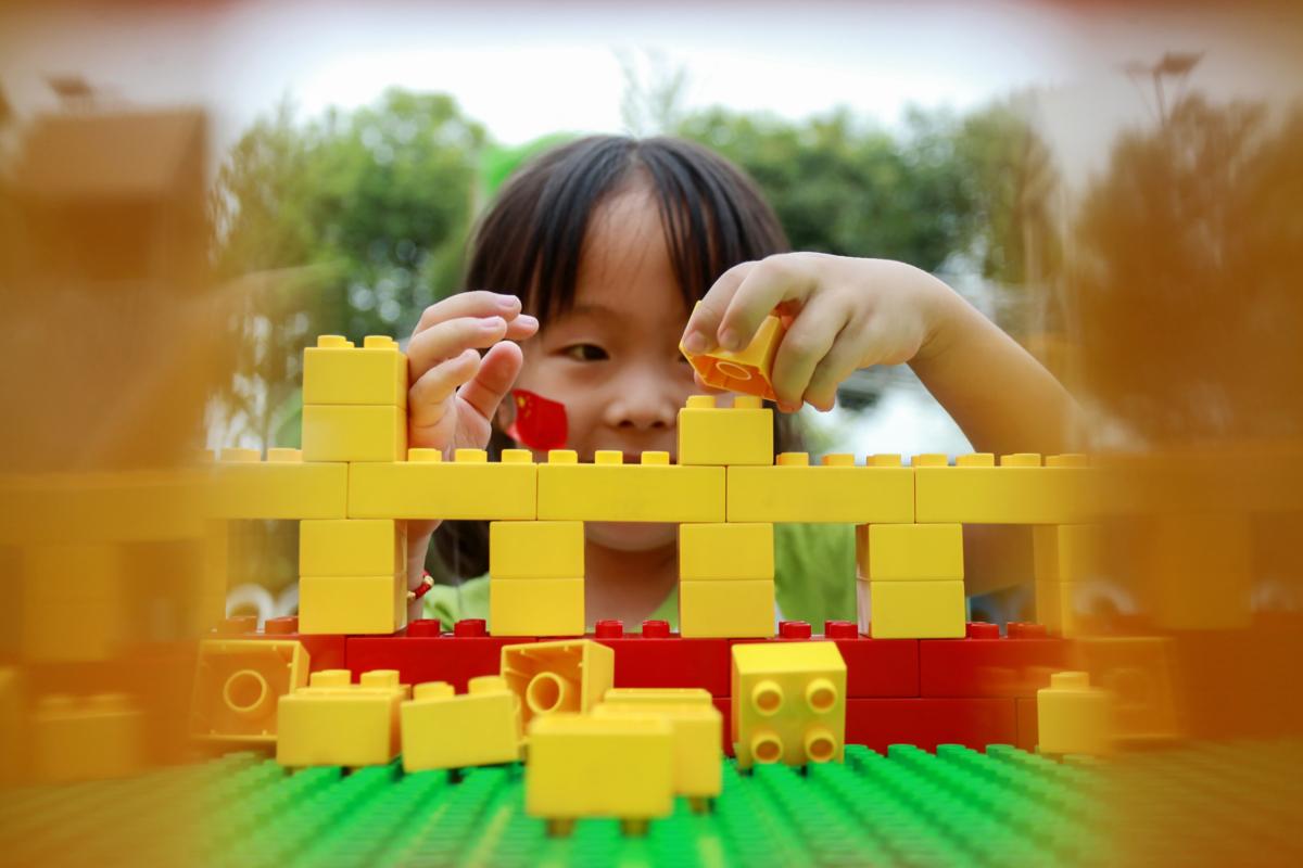 A girl building a model of Tiananmen Gate with toy bricks in Yangzhou in China's eastern Jiangsu province, on Sep. 3, 2019. (STR/AFP via Getty Images)