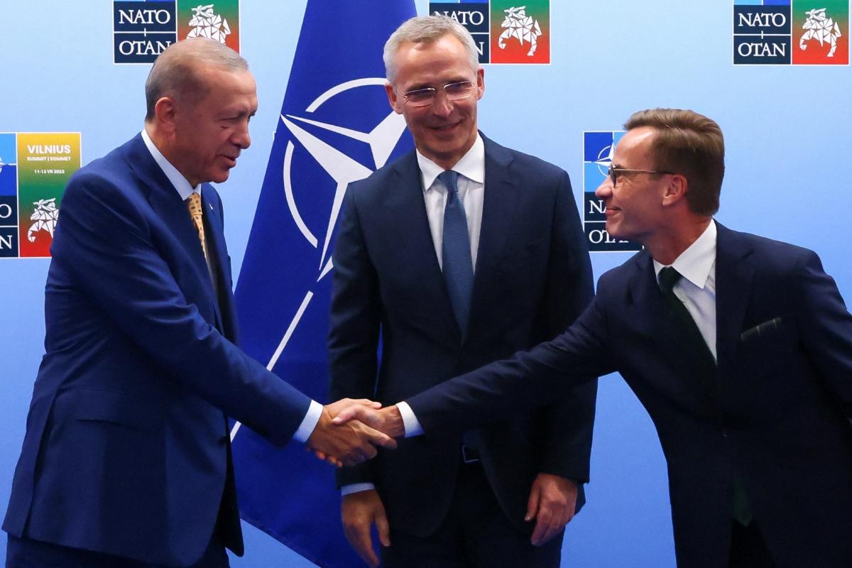 Turkish President Tayyip Erdogan (L) and Swedish Prime Minister Ulf Kristersson (R) shake hands next to North Atlantic Treaty Organization (NATO) Secretary General Jens Stoltenberg prior to their meeting, on the eve of a NATO summit, in Vilnius, Lithuania, on July 10, 2023. (Yves Herman/Pool via Reuters)