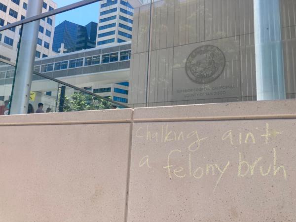 Chalk writings left by demonstrators are seen on the exterior of San Diego Central Courthouse during a protest against the arrests of three University of California–San Diego student workers who allegedly vandalized campus facility with non-chalk markers, in San Diego on July 10, 2023. (Courtesy of Philip Zhu)