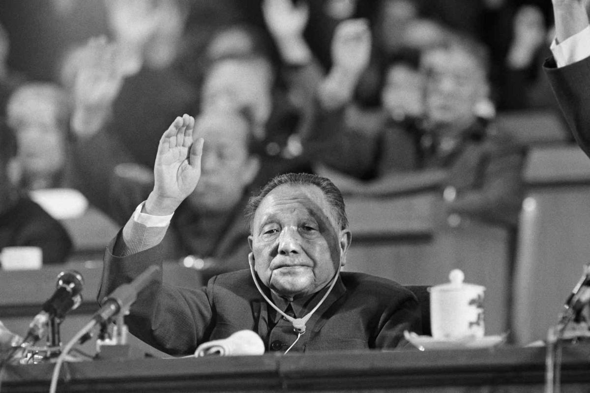 Chinese Communist Party leader Deng Xiaoping (L) raises his hand for a vote in Beijing on Nov. 1, 1987. (John Giannini /AFP via Getty Images)
