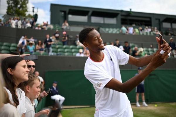 US player Christopher Eubanks poses for selfie pictures with supporters after winning against Greece's Stefanos Tsitsipas during their men's singles tennis match on the eighth day of the 2023 Wimbledon Championships at The All England Tennis Club in Wimbledon, southwest London, on July 10, 2023. (Daniel Leal/AFP via Getty Images)