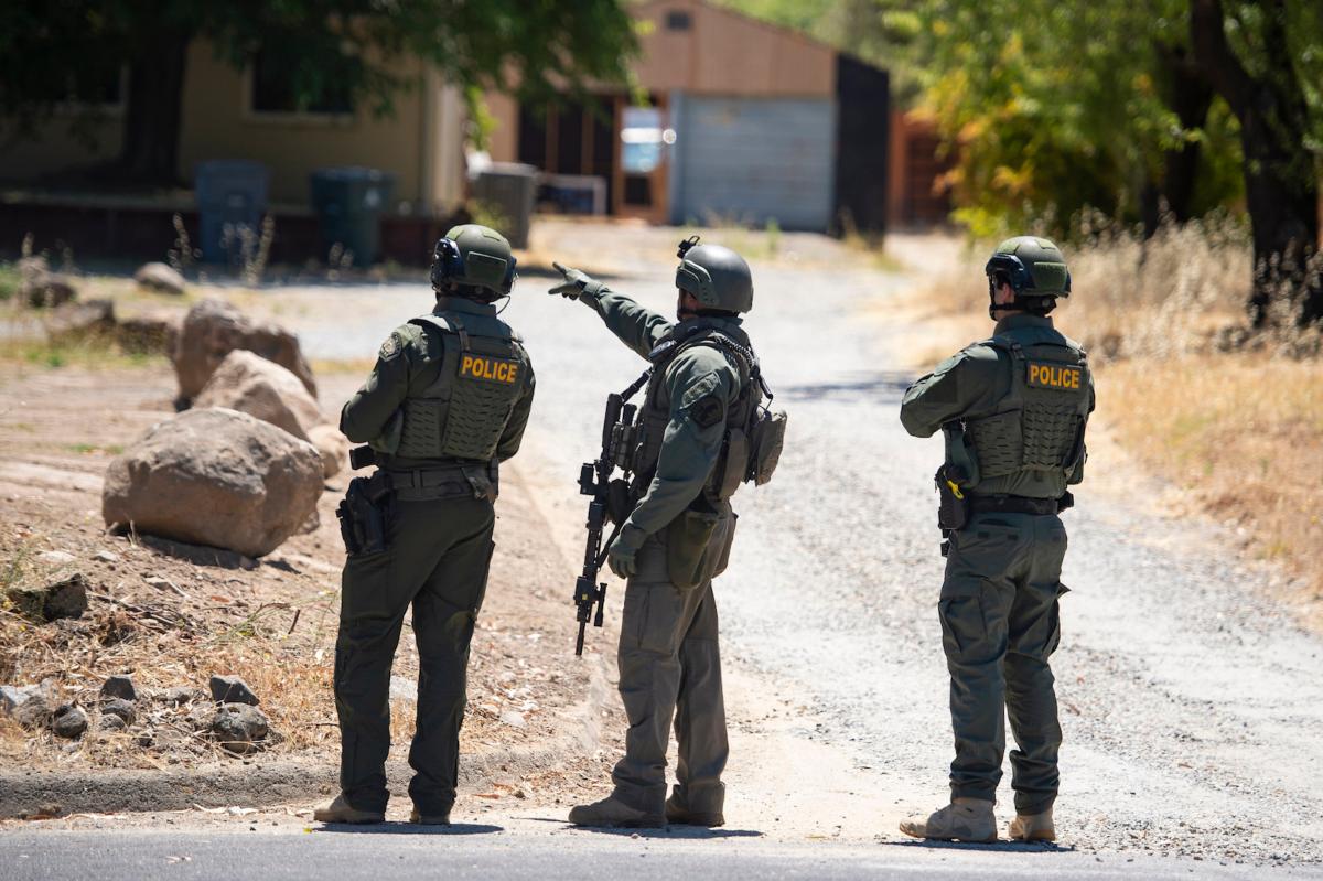 A Placer County Sheriff's deputy, joined by two police officers, points toward a home on Greenbrae Road in Rocklin, Calif., on July 9, 2023. (Sara Nevis/The Sacramento Bee via AP)
