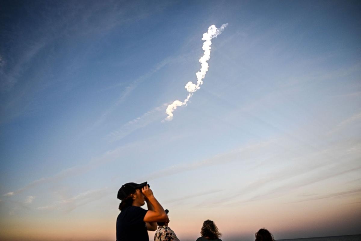 People watch the launch of a SpaceX Falcon 9 rocket carrying 21 second-generation Starlink satellites from Space Launch Complex 40 at NASA's Kennedy Space Center, in Cocoa Beach, Fla., on Feb. 27, 2023. (Chandan Khanna/AFP via Getty Images)