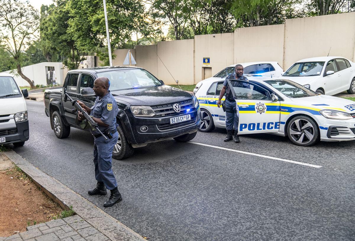 South African Police Service (SAPS) officers gather at a house in the Bryanston suburb of Johannesburg, on Nov. 17, 2022, following the arrest of a 46-year-old Israeli fugitive who has been the subject of an Interpol red notice since 2015. (AFP via Getty Images)