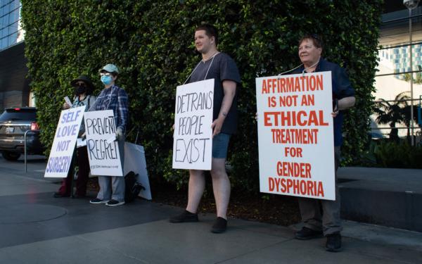 Demonstrators reach out to Los Angelinos about complications associated with gender reassessment surgeries in downtown Los Angeles on March 12, 2022. (John Fredricks/The Epoch Times)