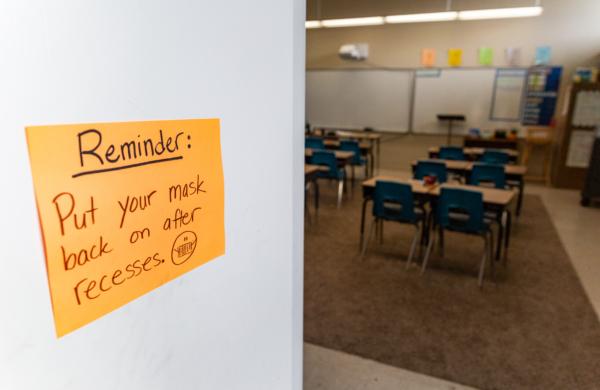 A mask reminder marks the door of a classroom in Tustin, Calif., on March 10, 2021. (John Fredricks/The Epoch Times)