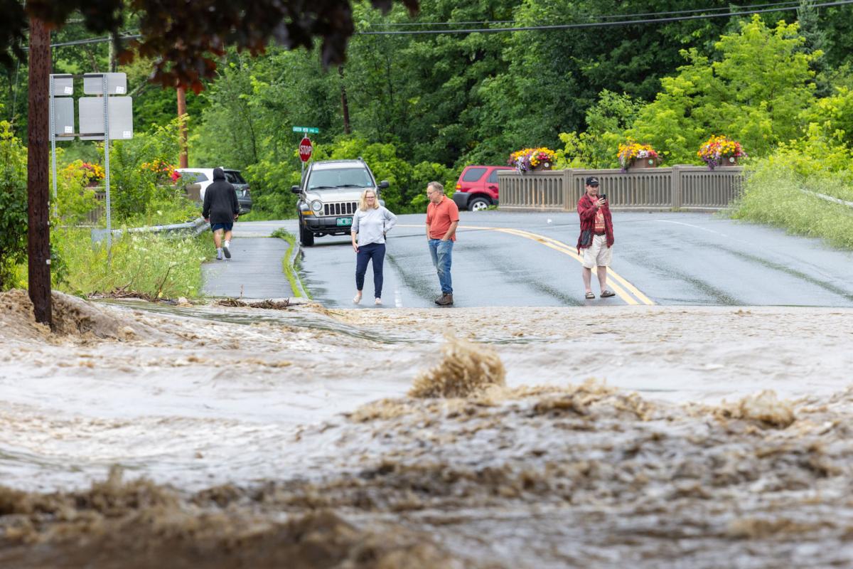 Onlookers check out a flooded road in Chester, Vt., on July 10, 2023. (Scott Eisen/Getty Images)