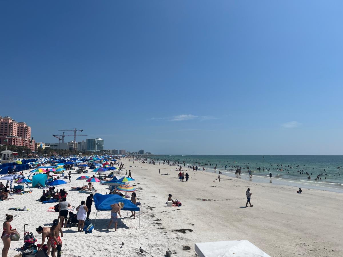 Tourists and locals play in the surf and sand in Clearwater Beach, Fla., on July 2, 2023. (Nanette Holt/The Epoch Times)
