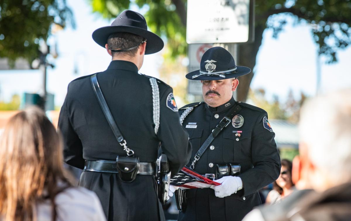 Police officers fold the American Flag in the City of Orange, Calif., on Nov. 11, 2021. Mayors say they are still dealing with the fallout from George Floyd's death in 2020. (John Fredricks/The Epoch Times)