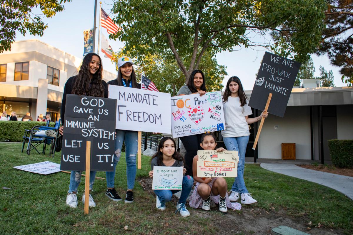 Students of PYLU School District hold up signs as parents gather to express concerns over mandatory vaccines at the Placentia Yorba Linda Unified School District building in Placentia, Calif., on Oct. 12, 2021. (John Fredricks/The Epoch Times)