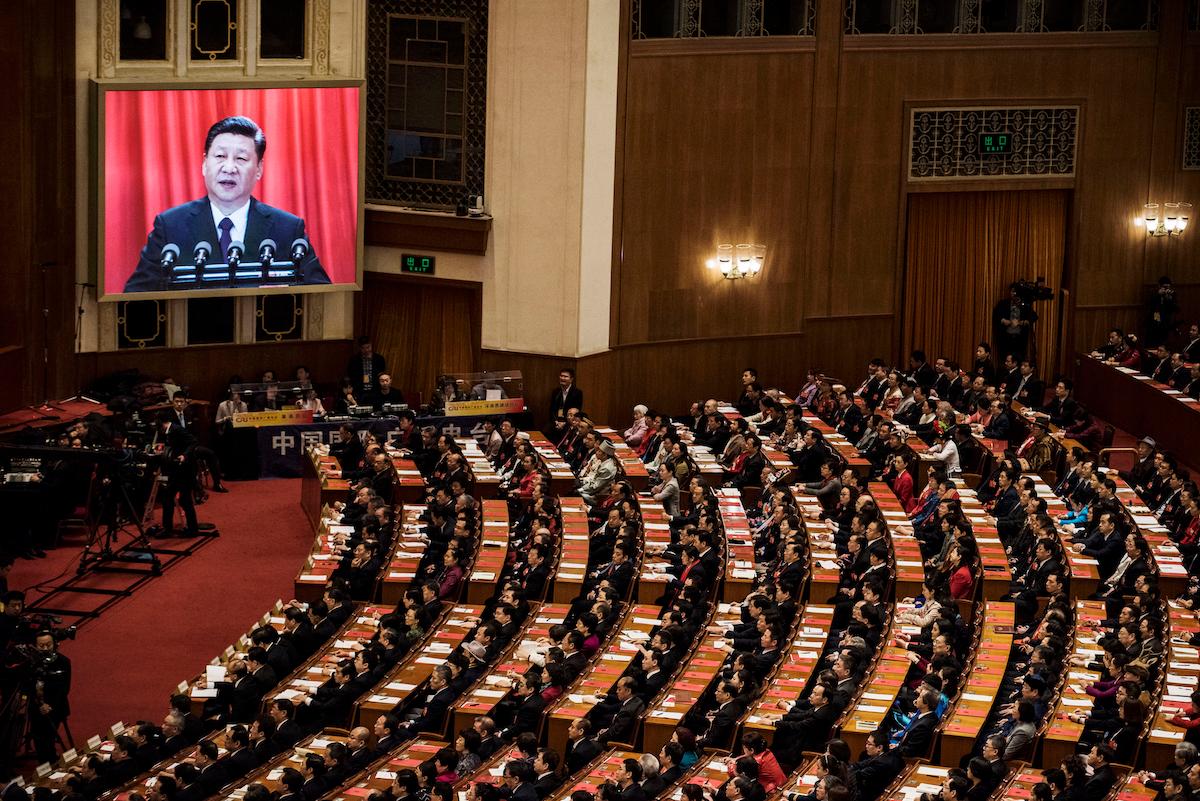 Delegates listen to a speech by China's leader Xi Jinping as he is seen on a large screen during the closing session of the National People's Congress at The Great Hall Of The People in Beijing, on March 20, 2018. (Kevin Frayer/Getty Images)