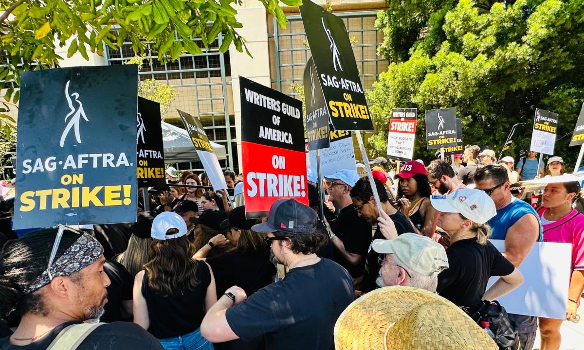 Members of the Screen Actors Guild-American Federation of Television and Radio Artists (SAG-AFTRA) on strike hold signs in front of Warner Bros. Studios in Burbank, Calif., on July 14, 2023. (Jill McLaughlin/The Epoch Times)