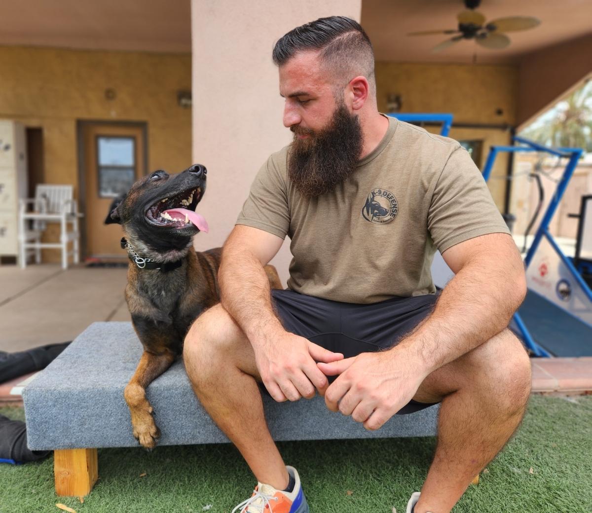 Chris Kamma, business development director at K9 Defense in Scottsdale, Ariz., spends quality time with Ditto, a 3-year-old Belgian Malinois "clone" on July 11, 2023. (Allan Stein/The Epoch Times)