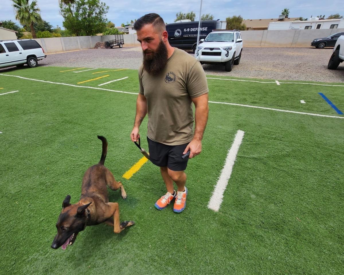 K9 Defense Business Development Director Chris Kamma takes Ditto, a Belgian malinois, out for a run on July 11, 2023. (Allan Stein/The Epoch Times)