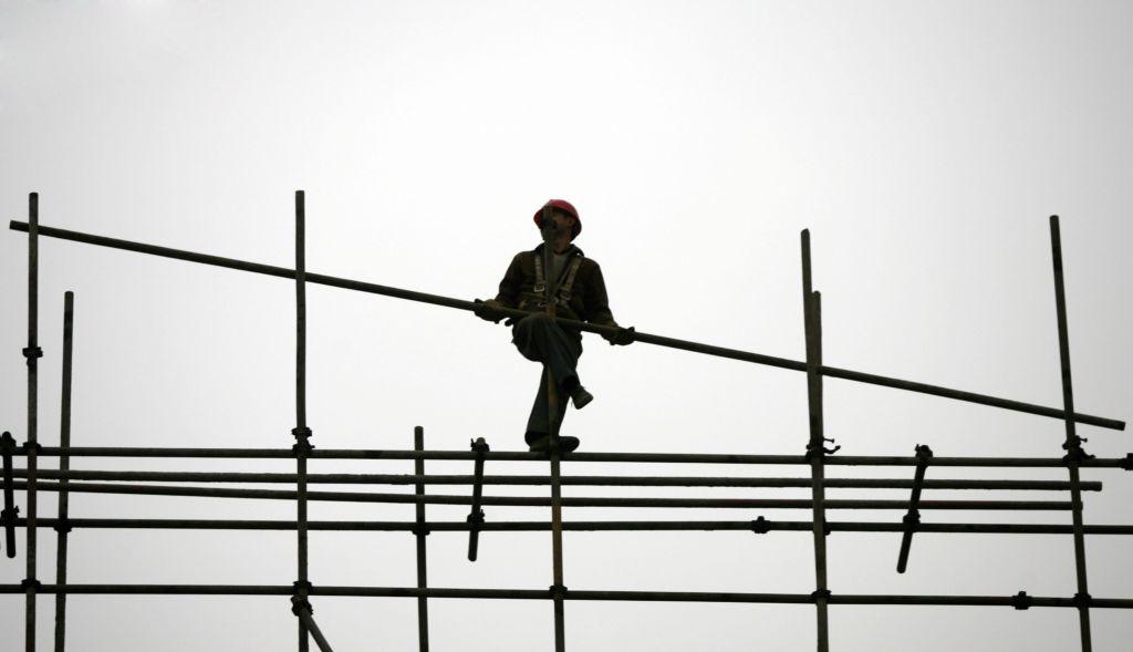 A migrant worker erects scaffolding at a construction site in Chongqing Municipality, China, on Jan. 13, 2007. (China Photos/Getty Images)