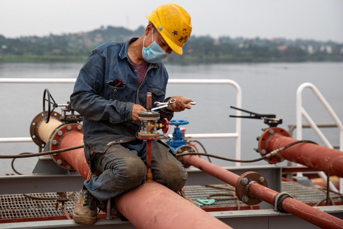A Chinese expatriate worker works on an oil tanker built on the banks of Lake Victoria at a new fuel storage complex in Entebbe, Uganda, on Jan. 15, 2022. (Luke Dray/Getty Images)