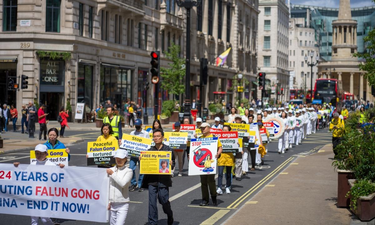 Hu Xuanming (2nd row, R), whose mother is imprisoned in China, marching in a rally commemorating the 24th anniversary of the Chinese regime's ongoing persecution of Falun Gong, in London on July 15, 2023. (Yanning Qi/The Epoch Times)
