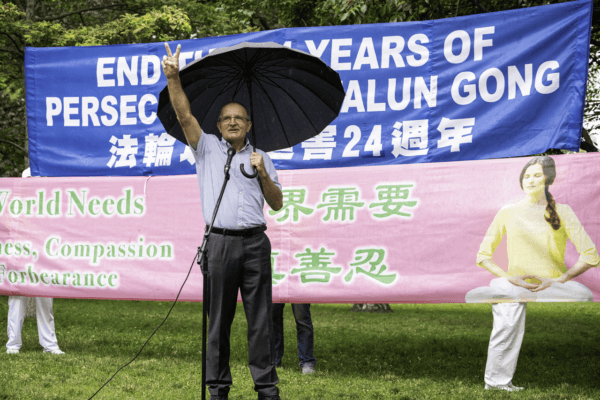 Former Conservative MP Wladyslaw Lizon raises his hand in a sign of victory to encourage Falun Gong practitioners as he condemns the Chinese regime for its persecution campaign, during a rally at Queen's Park in Toronto on July 15, 2023. (Evan Ning/The Epoch Times)