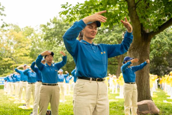 Falun Gong adherents perform the practice's meditative exercises at Queen's Park in Toronto on July 15, 2023.  (Evan Ning/The Epoch Times)