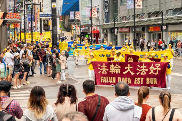 Hundreds of Falun Gong practitioners take part in a rally and a parade through downtown Toronto on July 15, 2023, to call on the Chinese regime to stop its persecution of Falun Gong. (Evan Ning/The Epoch Times)