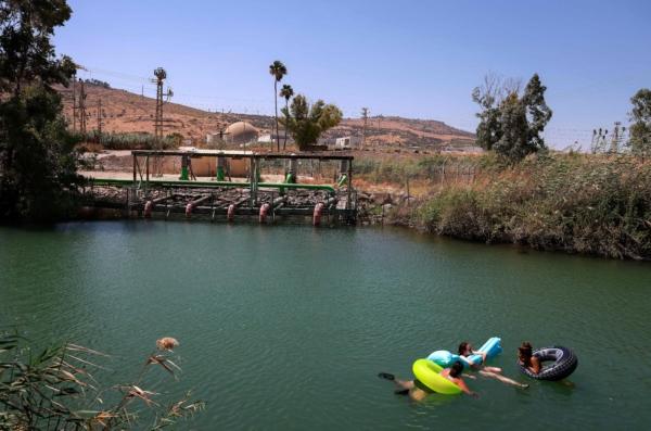 Israelis camping by the Jordan River near Kibbutz Degania, off the Sea of Galilee, or Lake Tiberias, one of the main water sources in Israel, on July 11, 2021. (MENAHEM KAHANA/AFP via Getty Images)