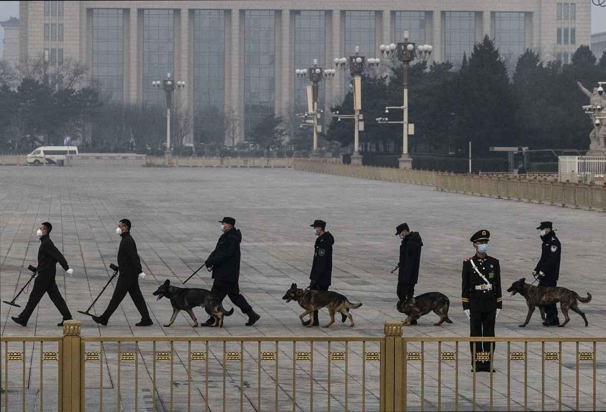 CCP police officers, accompanied by police dogs, conduct security scans at Tiananmen Square in Beijing on March 10, 2022. (Kevin Frayer/Getty Images)