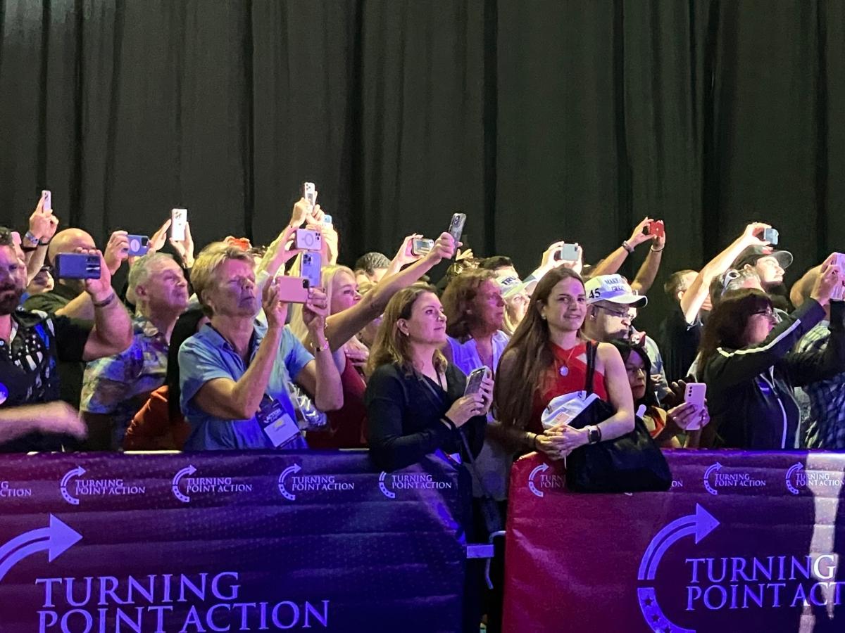  Fans of former President Donald Trump, corralled in an overflow area, aim their phone cameras toward him as he takes the stage at Turning Point Action Conference at the Palm Beach County Convention Center on July 15, 2023. (Janice Hisle/The Epoch Times)