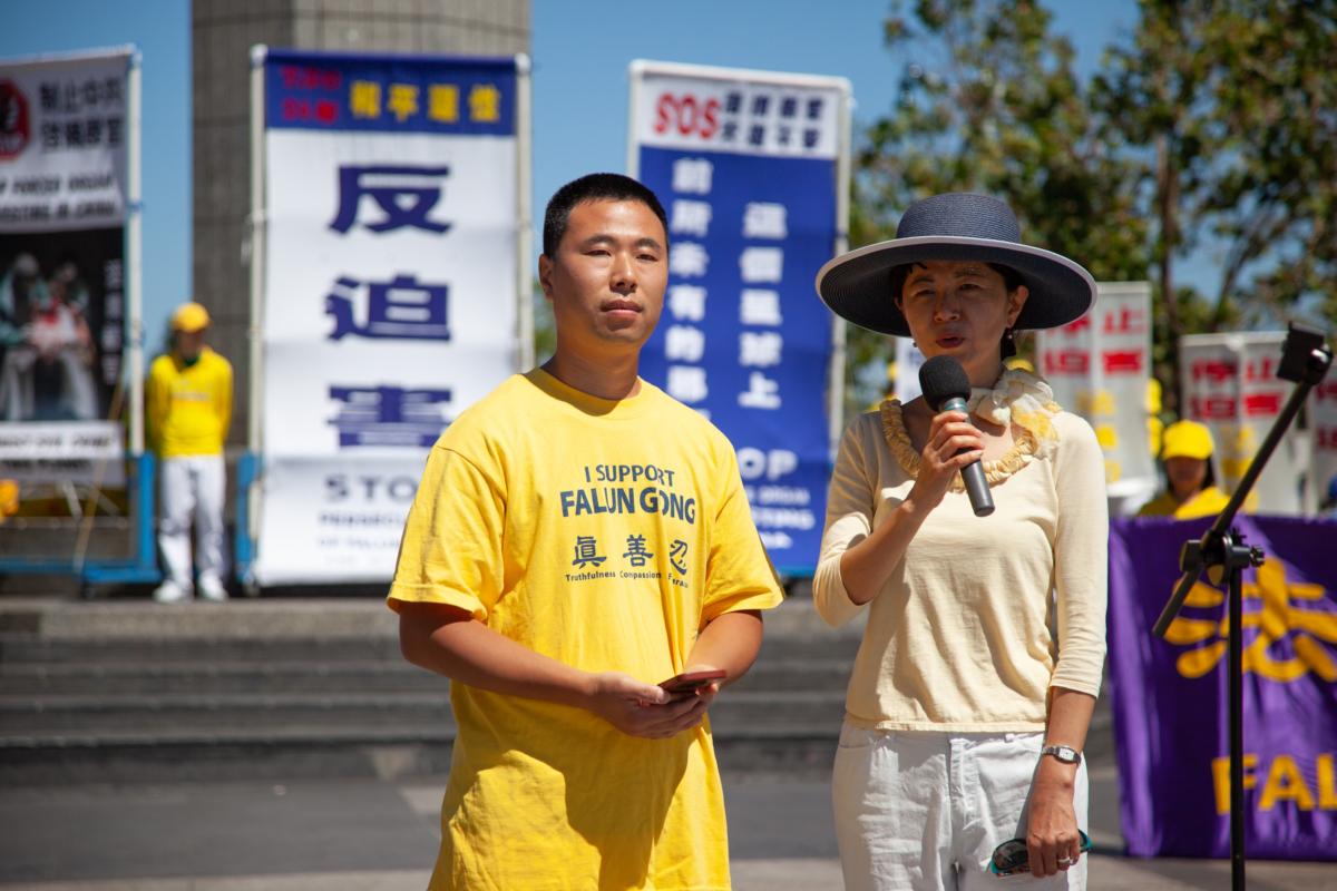 Wang Longbiao (L) looks on as a translator tells his story of escaping persecution in China at a rally in San Francisco on July 15, 2023. (Lear Zhou/The Epoch Times)