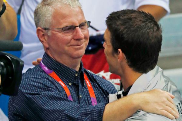 Coach Bob Bowman hugs United States' Michael Phelps after Phelps was honored as the most decorated Olympian at the Aquatics Centre in the Olympic Park during the 2012 Summer Olympics in London on Aug. 4, 2012. (Julio Cortez/AP Photo)