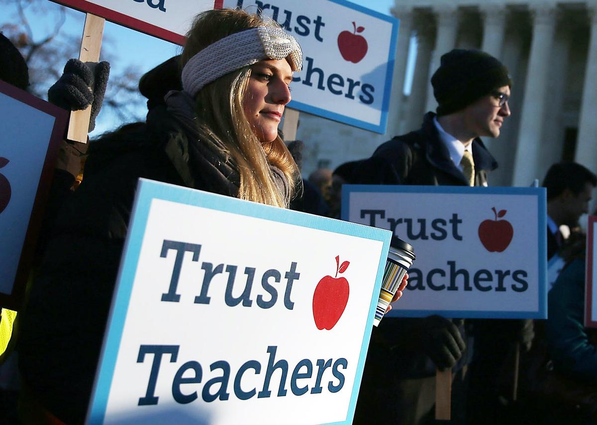 People hold signs in front of the U.S. Supreme Court building in Washington on Jan. 11, 2016. (Mark Wilson/Getty Images)