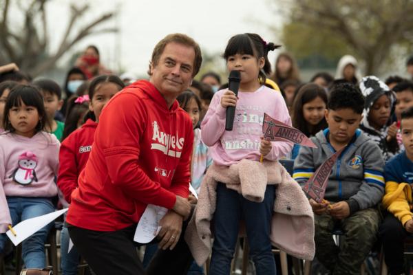 Sports talk show host Roger Lodge interacts with a student at an Angels Adopt-A-School event on April 11, 2023. (Courtesy of Angels Radio AM 830)
