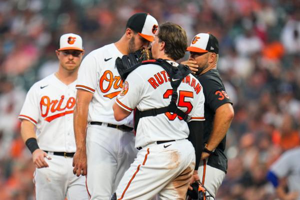 Baltimore Orioles starting pitcher Grayson Rodriguez, second from left, talks to catcher Adley Rutschman (35) and pitching coach/director of pitching Chris Holt (38) during the fourth inning of a baseball game against the Los Angeles Dodgers in Baltimore on July 17, 2023. (Julio Cortez/AP Photo)