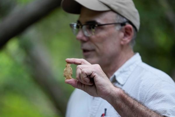 Professor Mark Rees holds a side notched, archaic projectile point at an archeological dig site in Kisatchie National Forest, La., on June 7, 2023. (Gerald Herbert/AP Photo)