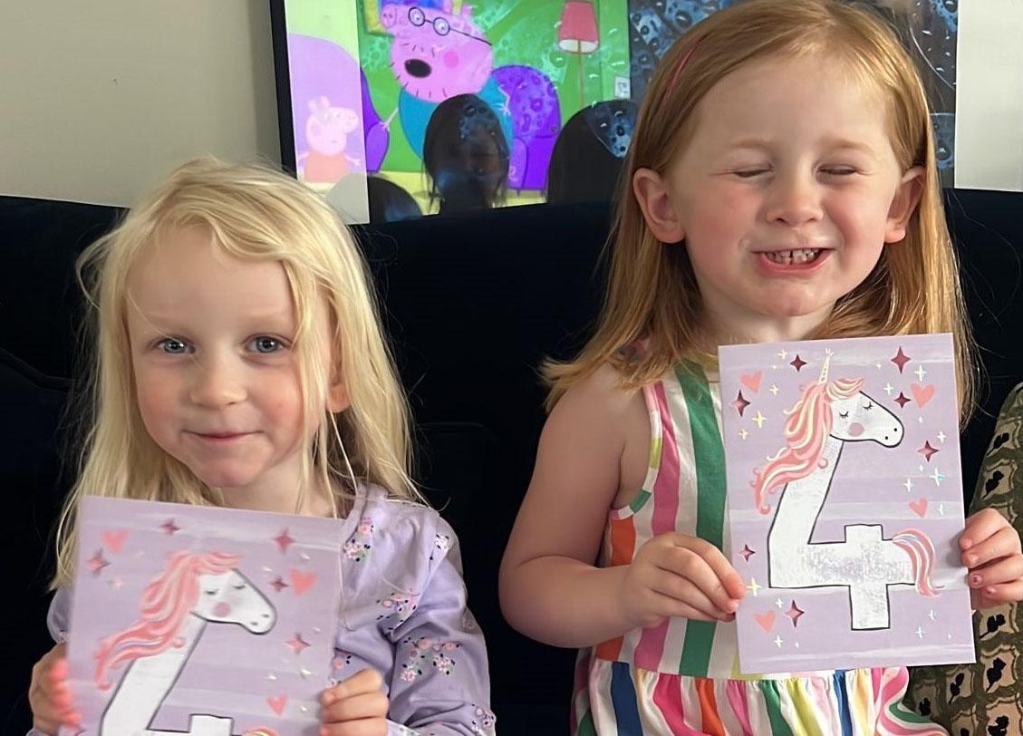 Sophia and Rose with their fourth birthday cards. (SWNS)