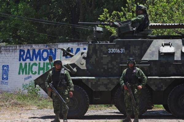 Mexican soldiers stand guard on a Panhard VCR at Guadalajara-Barra de Navidad highway, in Juchitlan, Jalisco State during a new operation to capture drug cartel leaders in May 2015. (Hector Guerrero/AFP via Getty Images)