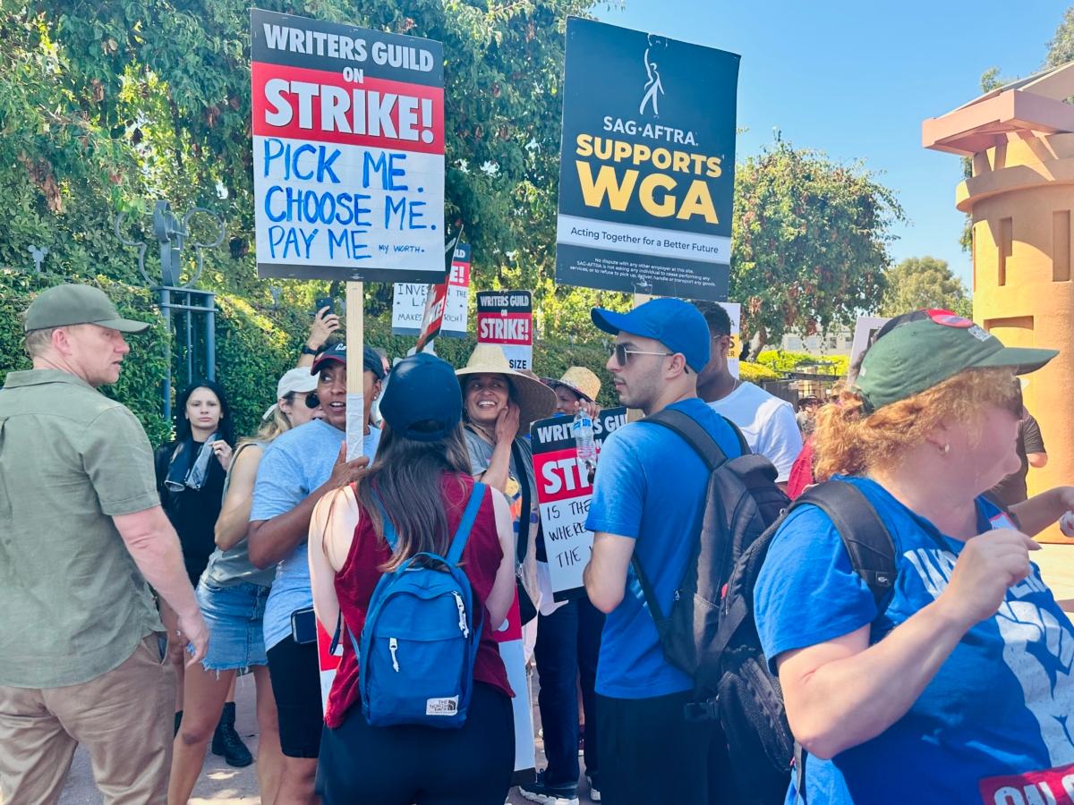 Members of the Writer’s Guild of America and Screen Actors Guild-American Federation of Television and Radio Artists (SAG-AFTRA) picket together outside Disney Studios in Burbank, Calif., on July 18, 2023, as temperatures reached the mid-90s. (Jill McLaughlin/The Epoch Times)